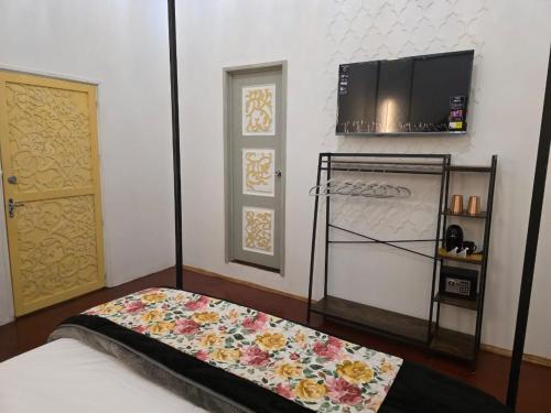 a room with a bed and a tv and a door at Casa Fiori San Miguel de Allende in San Miguel de Allende