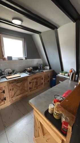a large kitchen with wooden cabinets and a window at Domek letniskowy Jemiołowo in Olsztynek