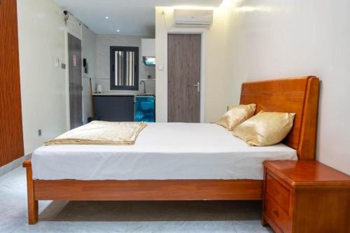 a bedroom with a large bed with a wooden headboard at Résidence Madior D3 in Dakar