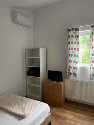 a bedroom with a bed and a dresser and a window at Canadian House in Sărata-Monteoru