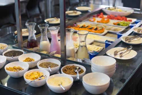 a buffet line with dishes and vases of food at Ramada by Wyndham Campinas Viracopos in Campinas