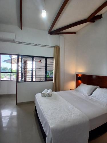 a bedroom with a large bed with two towels on it at HEYSEN Haus in Tarapoto