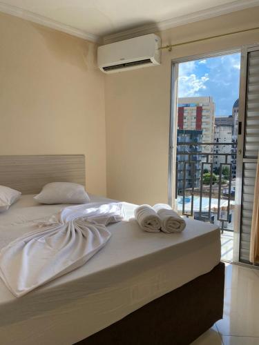 a bedroom with a bed with towels on it at Basilica Palace Hotel in Aparecida