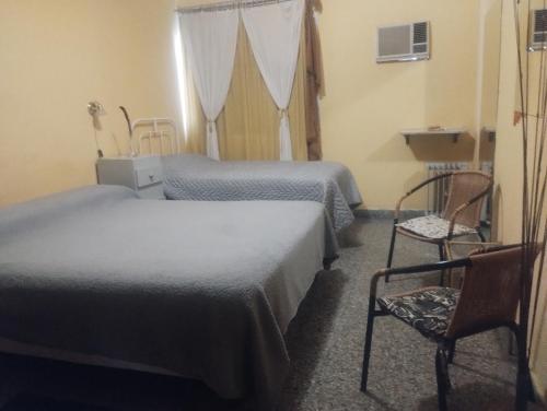 a hotel room with two beds and a chair at Toto in San Juan