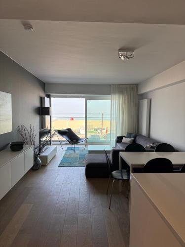 a living room with a couch and a table at Zeezicht Rubensplein - 3slpk - gratis parking in Knokke-Heist