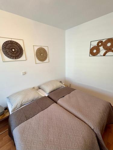 a bedroom with a bed and two pictures on the wall at Apartment Leitha Living Cozy in Götzendorf an der Leitha