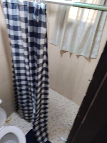 a bathroom with a black and white shower curtain at Casa Amarilla hostel in Bajo Boquete