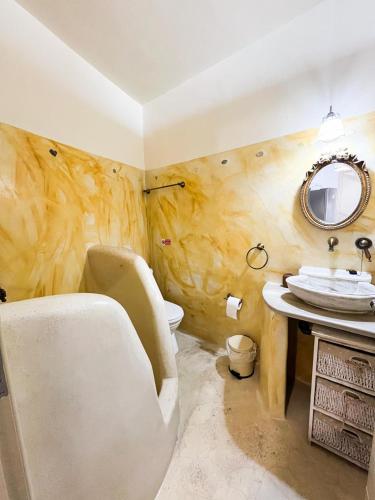 a bathroom with a sink and a toilet and a mirror at Aegean Breeze in DYO CHORIA TINOS in Triandáros