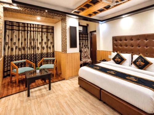 a hotel room with a bed and a table and chairs at Anandam Near Mall Road in Shimla