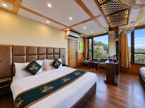 a bedroom with a large bed with a large window at Anandam Near Mall Road in Shimla