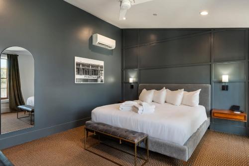 a bedroom with a large white bed and a chair at Superior King Room at The Emerald in Beaufort