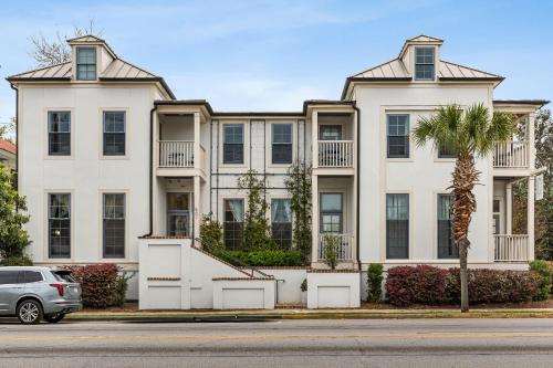 a white building with a palm tree in front of it at Superior King Room at The Emerald in Beaufort