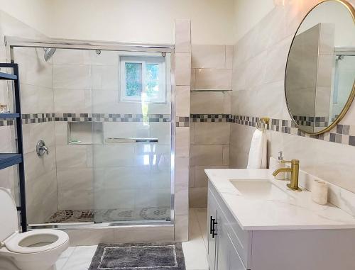 a bathroom with a shower and a toilet and a sink at Home Escape Negril Unit 3 in Negril