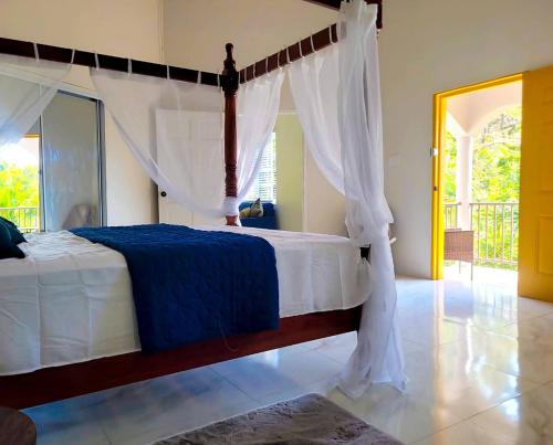 a bedroom with a bed with a canopy at Home Escape Negril Unit 3 in Negril