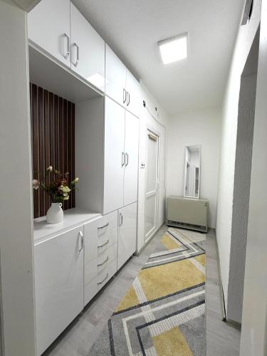 a bathroom with white cabinets and a rug at Spring Studio Apartment in Prizren