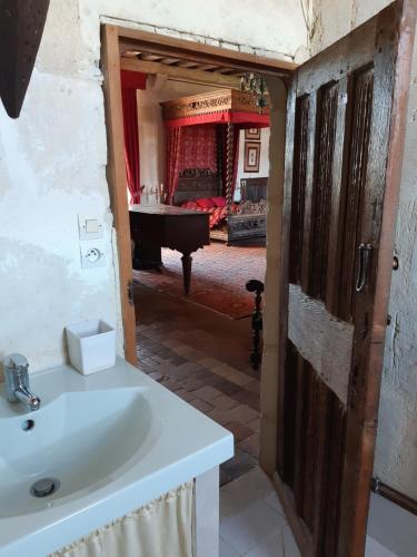 a bathroom with a sink and a room with a grand piano at Chateau de Chémery in Chémery
