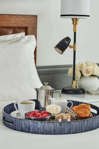 a tray of breakfast foods and coffee on a bed at Pendry San Diego in San Diego