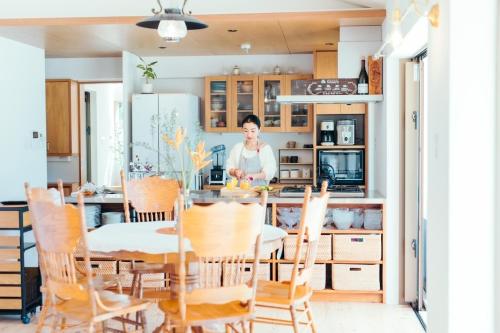 a woman in a kitchen with a table and chairs at MANANI - Vacation STAY 16628v in Nago