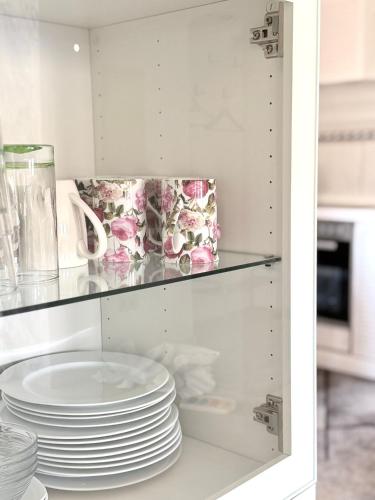 a cupboard with plates and dishes in it at KM APPARTS Wesel 6 in Wesel