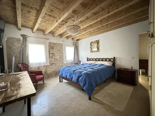 a bedroom with a large bed with a blue comforter at Papiria Residence in Piovene Rocchette