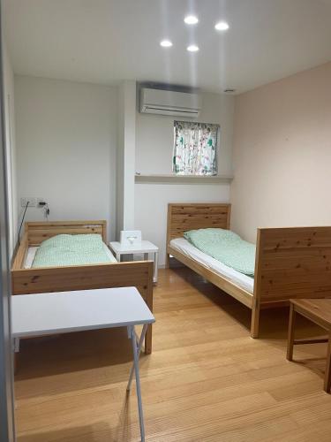 a room with two beds and a table in it at ReFa room由来House in Kumamoto