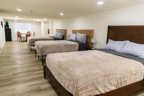 a hotel room with three beds and a table at Duchesne River LLC in Duchesne