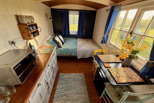 a small kitchen with a bed in a tiny house at Shepherd's Hut near Oxford in Cumnor