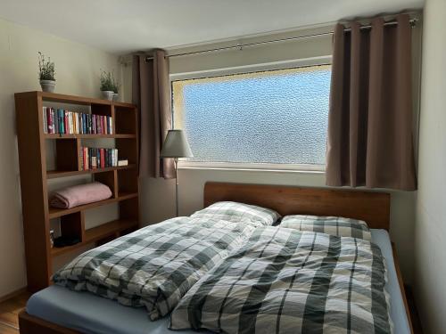 a bedroom with a bed and a window and a book shelf at Ruhige Gartenwohnung in Königs Wusterhausen