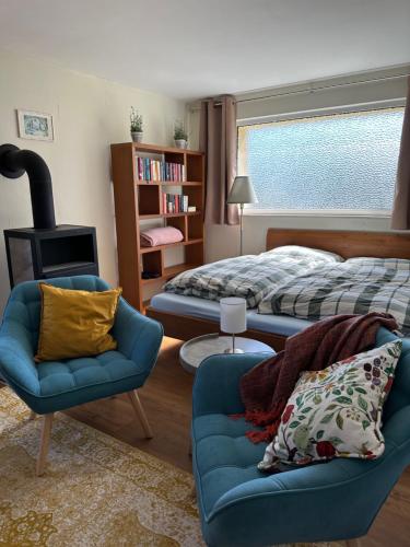 a bedroom with a bed and a couch and a chair at Ruhige Gartenwohnung in Königs Wusterhausen