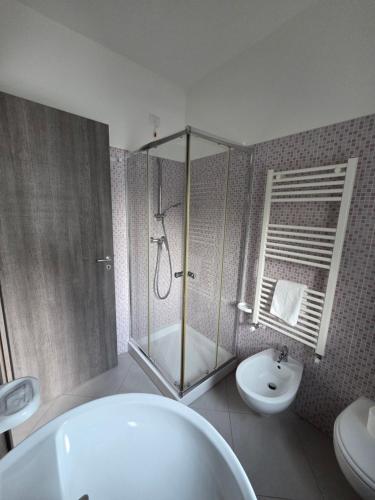 a bathroom with a tub and a toilet and a sink at Hotel Rodian in Acquappesa