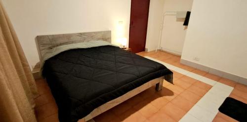 a bedroom with a bed with a black comforter at Shillong Serviced Apartment in Shillong