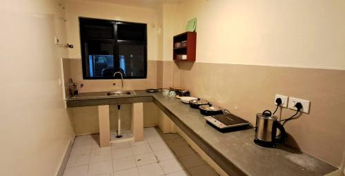 a small kitchen with a counter and a sink at Shillong Serviced Apartment in Shillong