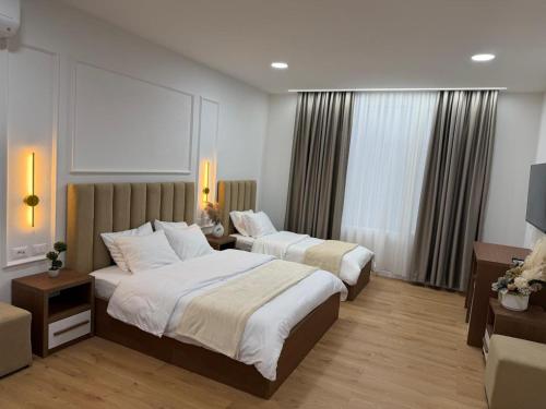 a hotel room with two beds and a television at Loris Rooms in Yrshek