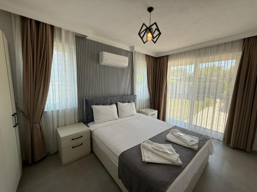 a bedroom with a bed and a large window at Villa Atay in Dalyan