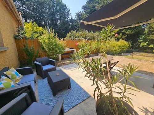 a patio with couches and tables and plants at Chez Diane et Bruno in Pernes-les-Fontaines