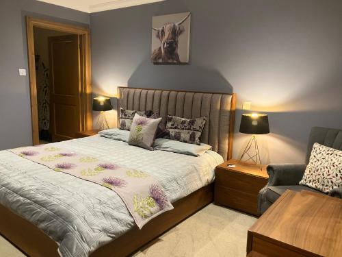 a bedroom with a large bed and a chair at Strath View on the NC 500 in Culbokie
