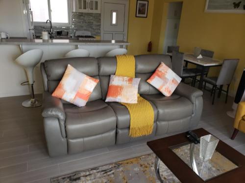 a living room with a leather couch with pillows on it at JemmRose Suites in Choc