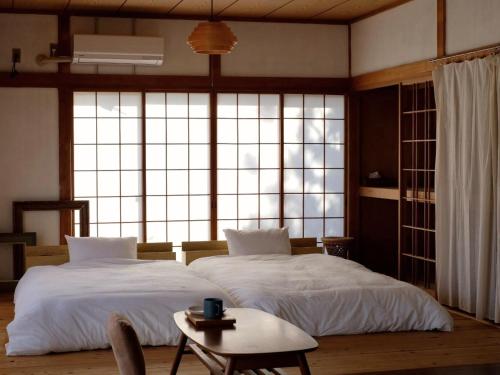 two beds in a room with a large window at OURoom UMIBE-Hokota - Vacation STAY 58188v in Hokota