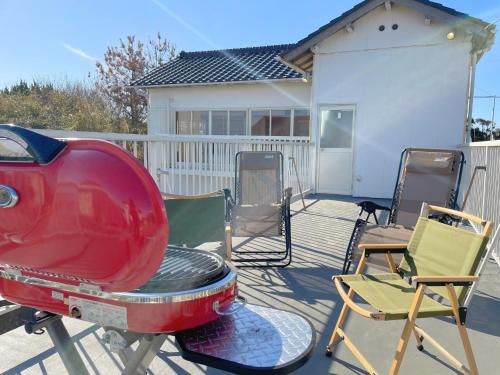 a yard with chairs and a red appliance on a porch at OURoom UMIBE-Hokota - Vacation STAY 58188v in Hokota