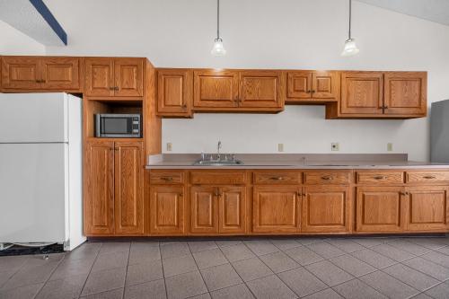 a kitchen with wooden cabinets and a sink at Indiana Beach Hotel in Monticello