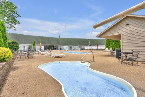 a hot tub in a yard with tables and chairs at Indiana Beach Hotel in Monticello