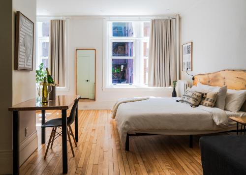 ein Schlafzimmer mit Bett, Tisch und Fenster in der Unterkunft Lofts Le Petit Champlain in Québec