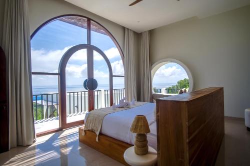 a bedroom with a bed and a large window at Villa Kai Nusa Penida in Sampalan