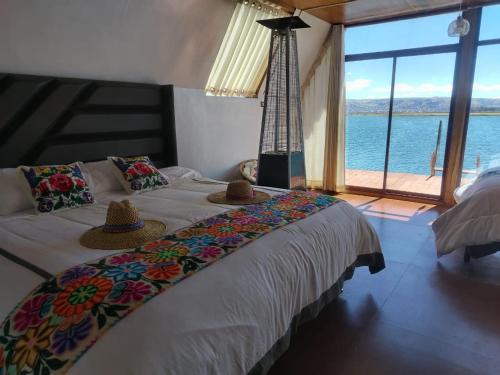 a bedroom with a large bed with hats on it at Jutma Titicaca Lodge in Puno
