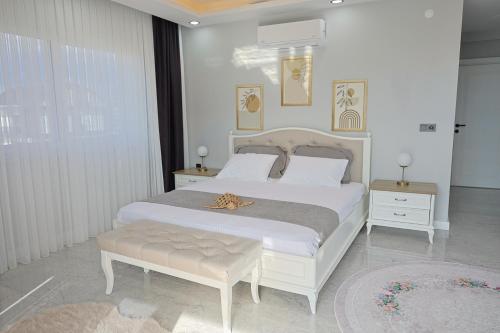 a bedroom with a large white bed with a gold ribbon on it at Vıllaozden in Belek