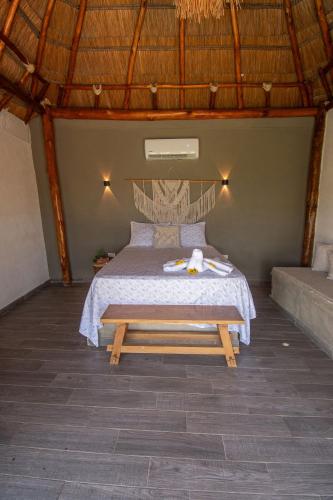 a bedroom with a bed with a wooden frame at AMALIFE Beach Club & Hotel in Tierra Bomba