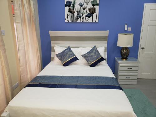 a blue bedroom with a bed with two pillows at JemmRose Suites in Choc
