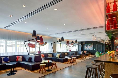 a hotel lobby with couches and tables and chairs at citizenM Paris Gare de Lyon in Paris