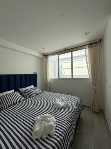 a bedroom with two white towels on a bed at Ballestas Suite in Pisco