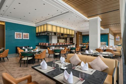 a restaurant with tables and chairs and a bar at Fairfield by Marriott Yulin in Yulin